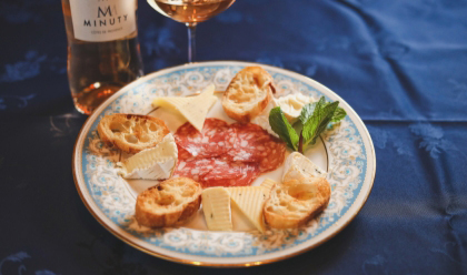 画像：青いテーブルクロスにお皿、その上に生ハムとサラミ、チーズが盛り付けされている